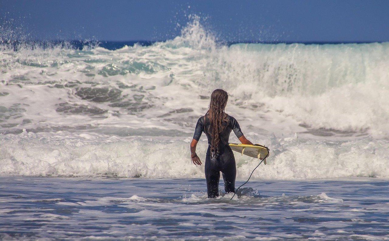 Beginner surfer with foam board in the ocean
