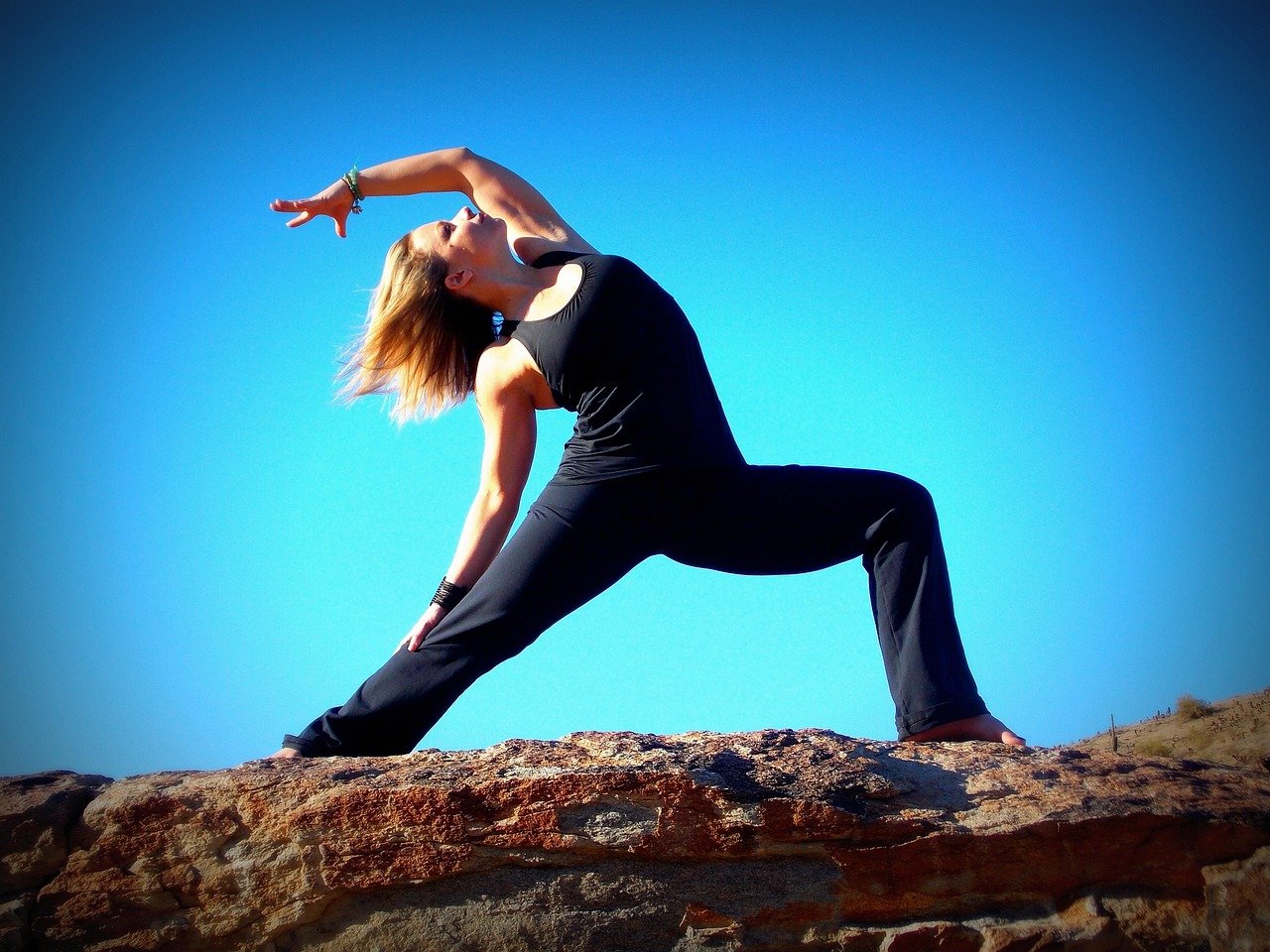 Woman practicing Warrior II yoga pose outdoors