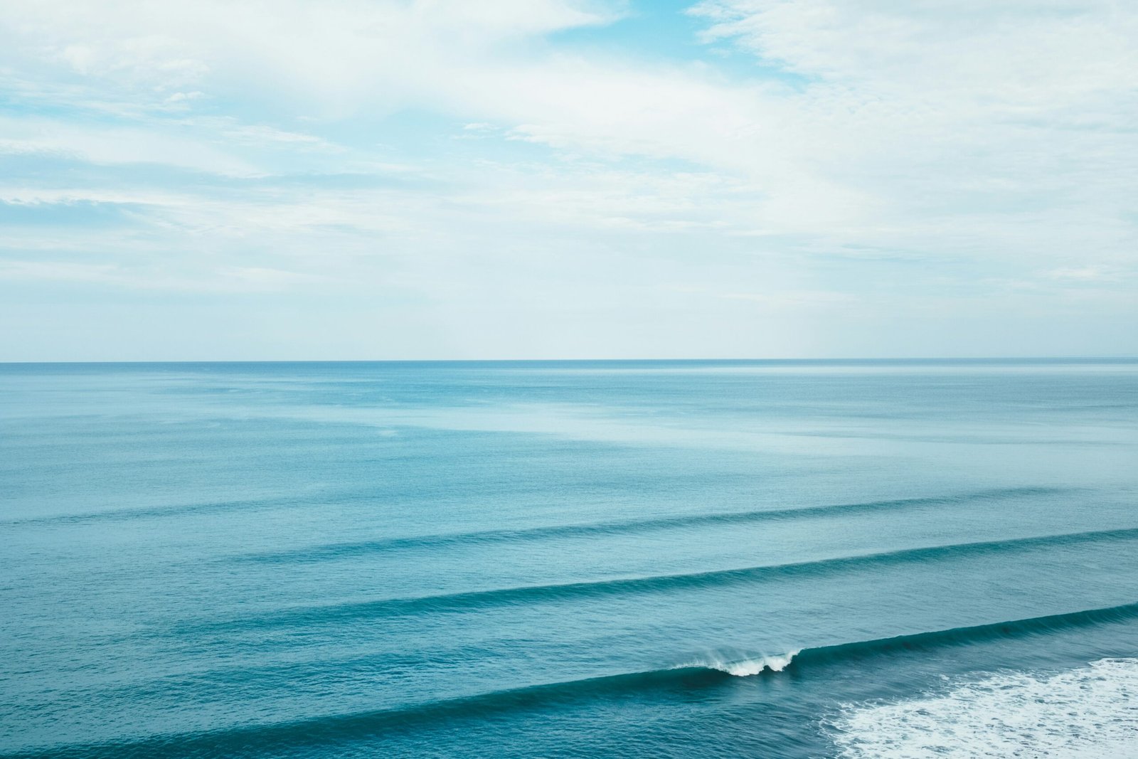 Aerial view of ocean swell lines rolling toward the shore