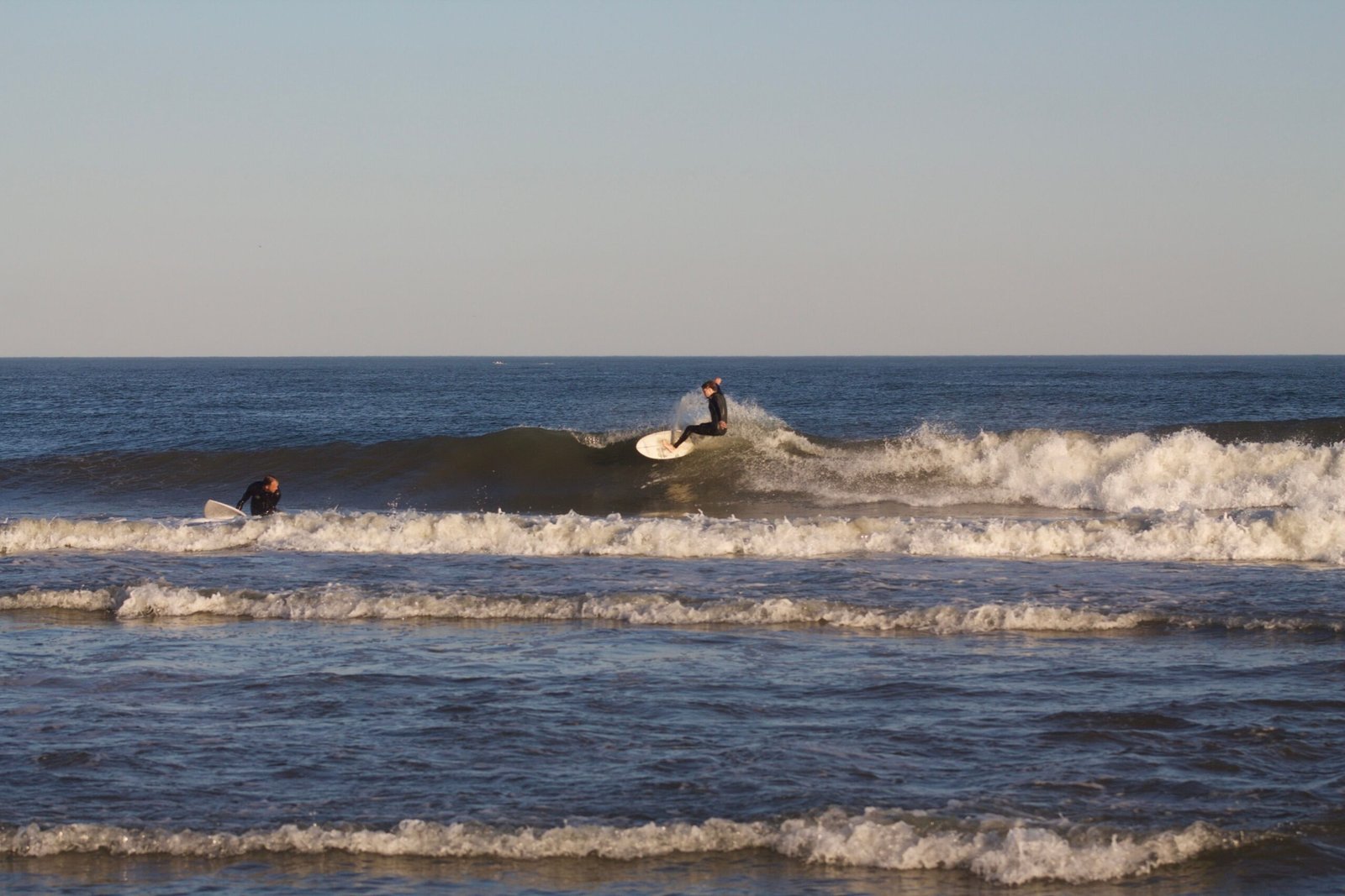 Two surfers sharing waves respectfully in a friendly lineup