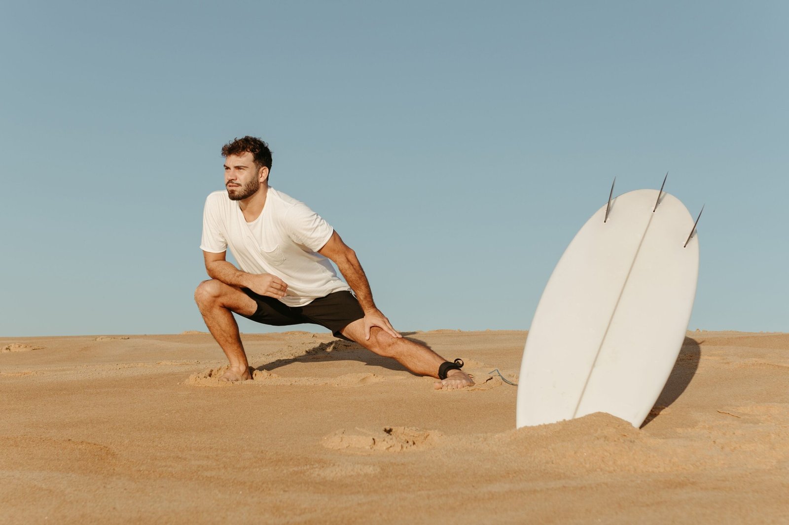 Surfer stretching on the beach before a cold water surfing session