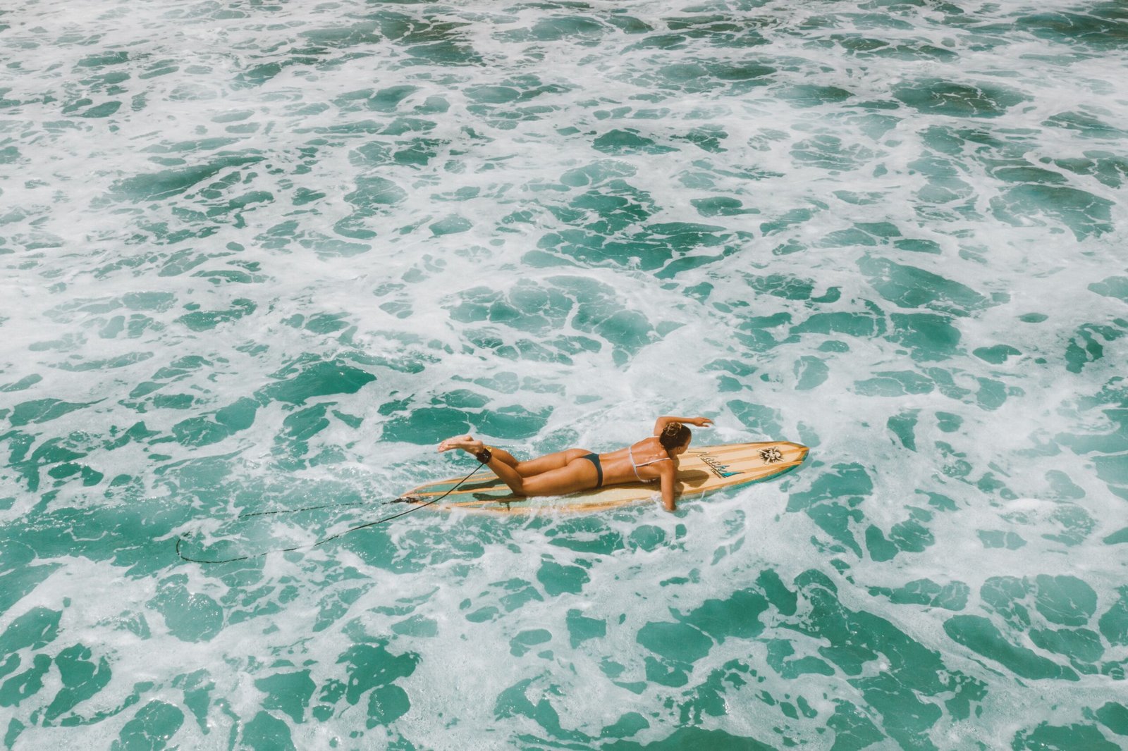 Surfer paddling out through ocean waves