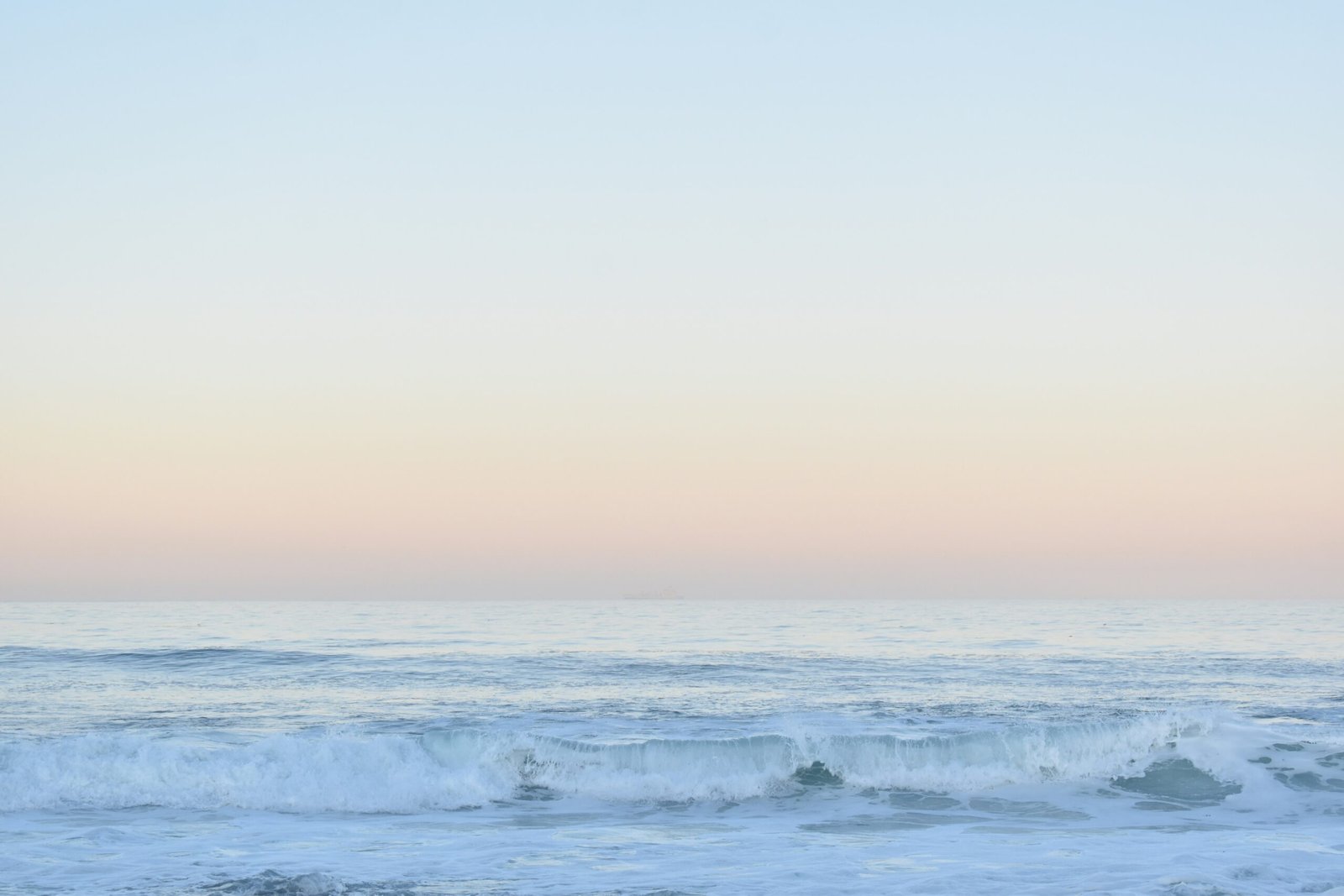 Group enjoying a surf and yoga wellness retreat by the ocean at sunrise